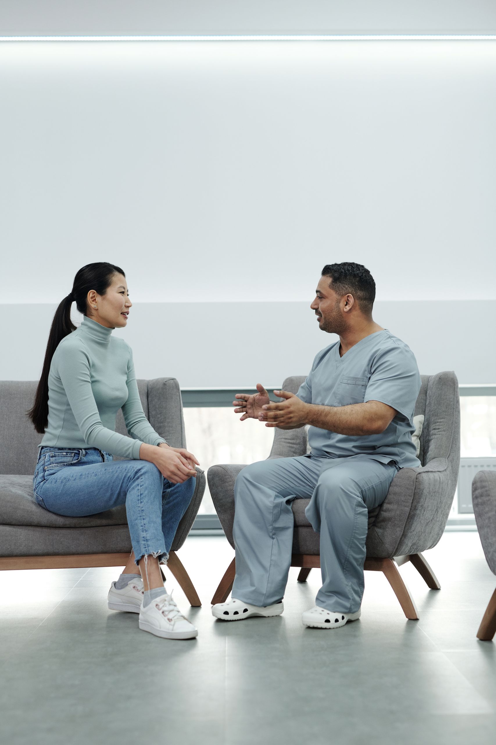A doctor consults with a patient in a modern, well-lit clinic environment.